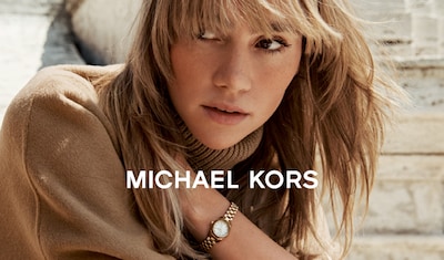 Michael Kors Banner - A close-up of a person wearing a stylish gold watch, alongside the text "MICHAEL KORS." image