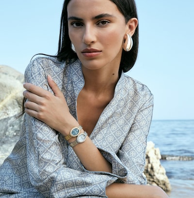 Female model on beach wearing Tory Burch watches image